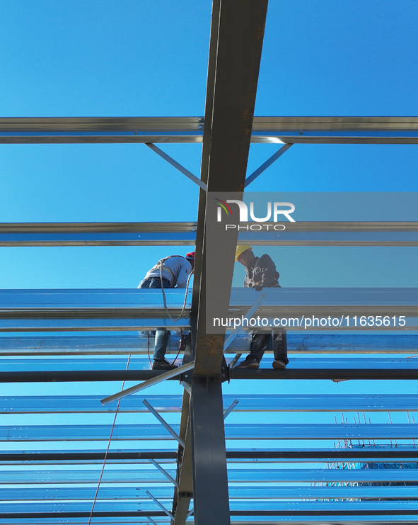 Workers work at the construction site of a standardized factory in Sihong Economic Development Zone in Suqian, Jiangsu province, China, on O...