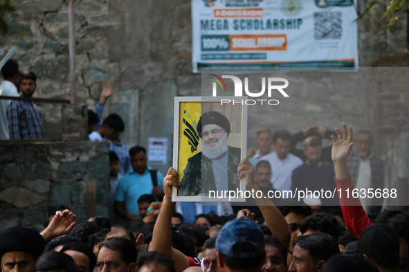 A Kashmiri Shia Muslim boy holds a placard of Hezbollah leader Sayyed Hassan Nasrallah during a protest against Israel following the killing...