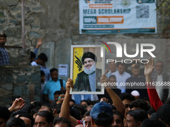 A Kashmiri Shia Muslim boy holds a placard of Hezbollah leader Sayyed Hassan Nasrallah during a protest against Israel following the killing...