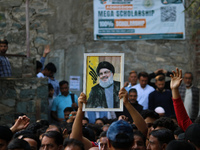 A Kashmiri Shia Muslim boy holds a placard of Hezbollah leader Sayyed Hassan Nasrallah during a protest against Israel following the killing...