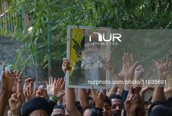 A Kashmiri Shia Muslim boy holds a placard of Hezbollah leader Sayyed Hassan Nasrallah during a protest against Israel following the killing...