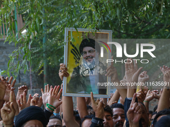 A Kashmiri Shia Muslim boy holds a placard of Hezbollah leader Sayyed Hassan Nasrallah during a protest against Israel following the killing...