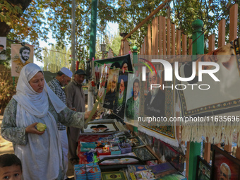 A Kashmiri Shia Muslim woman purchases a placard of Hezbollah leader Sayyed Hassan Nasrallah during a protest against Israel following the k...