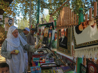 A Kashmiri Shia Muslim woman purchases a placard of Hezbollah leader Sayyed Hassan Nasrallah during a protest against Israel following the k...