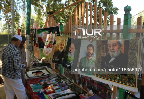 A Kashmiri Shia Muslim man purchases a placard of Hezbollah leader Sayyed Hassan Nasrallah during a protest against Israel following the kil...