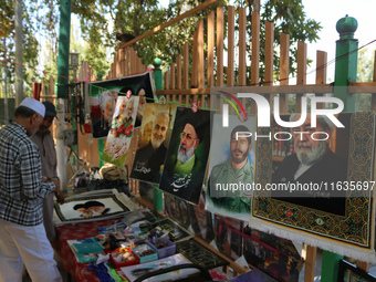 A Kashmiri Shia Muslim man purchases a placard of Hezbollah leader Sayyed Hassan Nasrallah during a protest against Israel following the kil...