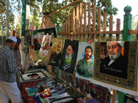 A Kashmiri Shia Muslim man purchases a placard of Hezbollah leader Sayyed Hassan Nasrallah during a protest against Israel following the kil...