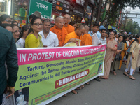 Members of the Buddhist community hold a banner as they participate in a silent protest and human chain against the ongoing violence and atr...