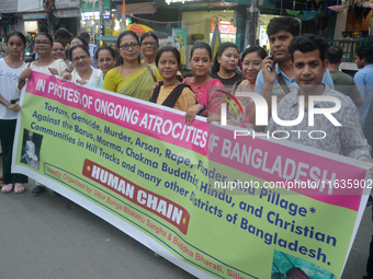 Members of the Buddhist community hold a banner as they participate in a silent protest and human chain against the ongoing violence and atr...