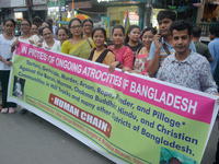 Members of the Buddhist community hold a banner as they participate in a silent protest and human chain against the ongoing violence and atr...