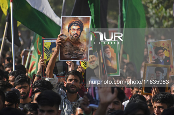 Shiite Muslims carry pictures of Hezbollah leader Hassan Nasrallah as they shout anti-Israel slogans during a demonstration to show their an...