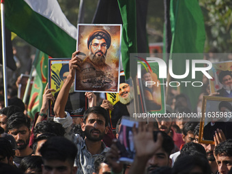 Shiite Muslims carry pictures of Hezbollah leader Hassan Nasrallah as they shout anti-Israel slogans during a demonstration to show their an...