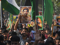 Shiite Muslims carry pictures of Hezbollah leader Hassan Nasrallah as they shout anti-Israel slogans during a demonstration to show their an...