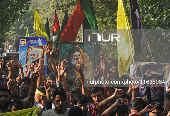 Shiite Muslims carry pictures of Hezbollah leader Hassan Nasrallah as they shout anti-Israel slogans during a demonstration to show their an...