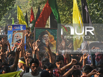 Shiite Muslims carry pictures of Hezbollah leader Hassan Nasrallah as they shout anti-Israel slogans during a demonstration to show their an...