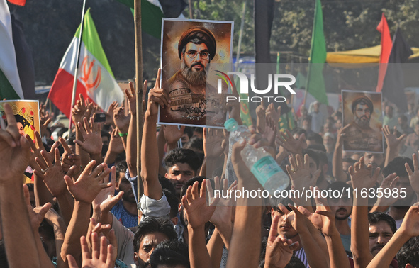 Shiite Muslims carry pictures of Hezbollah leader Hassan Nasrallah as they shout anti-Israel slogans during a demonstration to show their an...