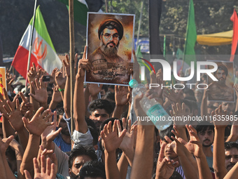 Shiite Muslims carry pictures of Hezbollah leader Hassan Nasrallah as they shout anti-Israel slogans during a demonstration to show their an...