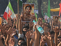 Shiite Muslims carry pictures of Hezbollah leader Hassan Nasrallah as they shout anti-Israel slogans during a demonstration to show their an...