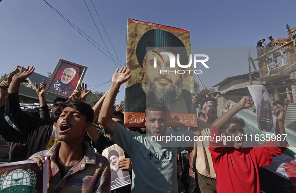 Shiite Muslims carry pictures of Hezbollah leader Hassan Nasrallah as they shout anti-Israel slogans during a demonstration to show their an...