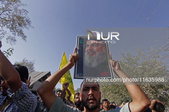 A Shiite Muslim carries a picture of Hezbollah leader Hassan Nasrallah during a demonstration to show his anger towards the killing of a lea...