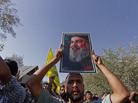 A Shiite Muslim carries a picture of Hezbollah leader Hassan Nasrallah during a demonstration to show his anger towards the killing of a lea...