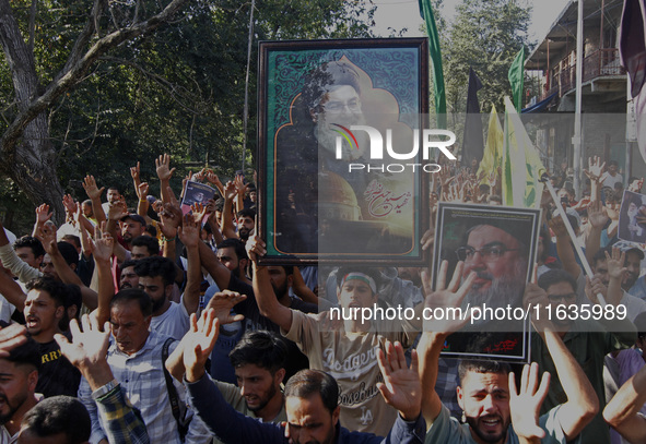 Shiite Muslims carry pictures of Hezbollah leader Hassan Nasrallah as they shout anti-Israel slogans during a demonstration to show their an...