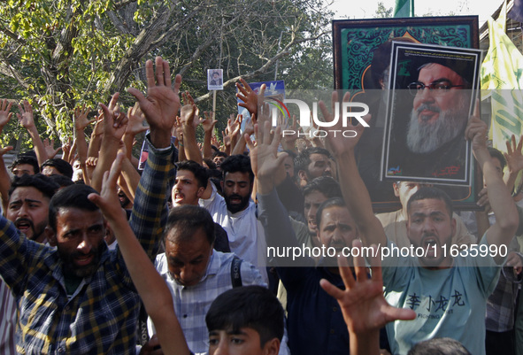 Shiite Muslims carry pictures of Hezbollah leader Hassan Nasrallah as they shout anti-Israel slogans during a demonstration to show their an...