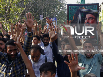 Shiite Muslims carry pictures of Hezbollah leader Hassan Nasrallah as they shout anti-Israel slogans during a demonstration to show their an...