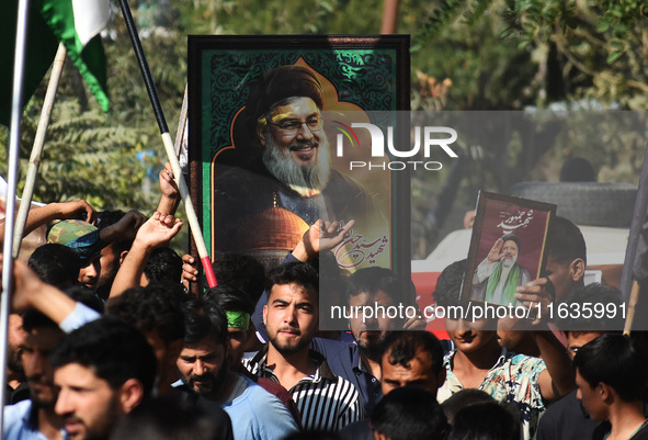 Shiite Muslims carry pictures of Hezbollah leader Hassan Nasrallah as they shout anti-Israel slogans during a demonstration to show their an...