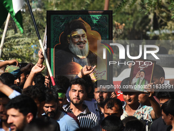 Shiite Muslims carry pictures of Hezbollah leader Hassan Nasrallah as they shout anti-Israel slogans during a demonstration to show their an...