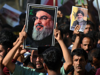 Shiite Muslims carry pictures of Hezbollah leader Hassan Nasrallah as they shout anti-Israel slogans during a demonstration to show their an...