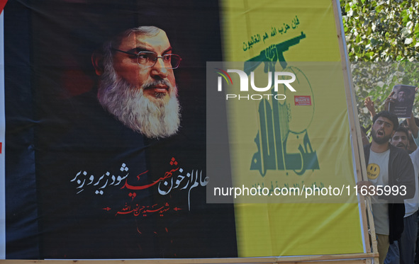 Shiite Muslims carry pictures of Hezbollah leader Hassan Nasrallah as they shout anti-Israel slogans during a demonstration to show their an...