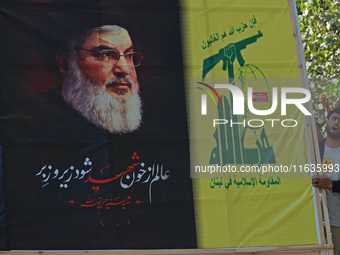 Shiite Muslims carry pictures of Hezbollah leader Hassan Nasrallah as they shout anti-Israel slogans during a demonstration to show their an...