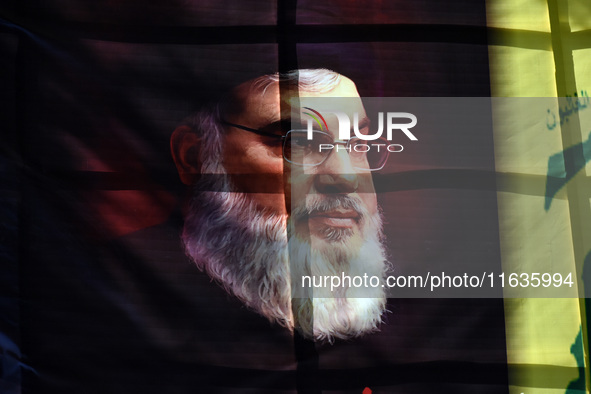 Shiite Muslims (not in picture) carry a picture of Hezbollah leader Hassan Nasrallah as they shout anti-Israel slogans during a demonstratio...