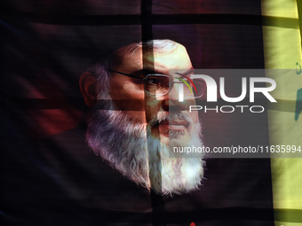 Shiite Muslims (not in picture) carry a picture of Hezbollah leader Hassan Nasrallah as they shout anti-Israel slogans during a demonstratio...