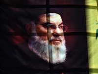 Shiite Muslims (not in picture) carry a picture of Hezbollah leader Hassan Nasrallah as they shout anti-Israel slogans during a demonstratio...