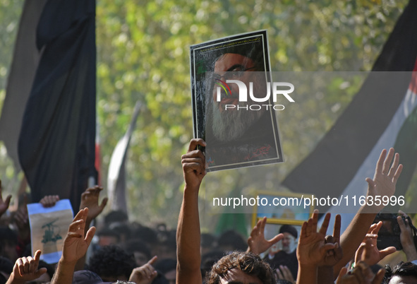 A Shiite Muslim carries a picture of Hezbollah leader Hassan Nasrallah during a demonstration to show his anger towards the killing of a lea...