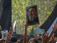 A Shiite Muslim carries a picture of Hezbollah leader Hassan Nasrallah during a demonstration to show his anger towards the killing of a lea...