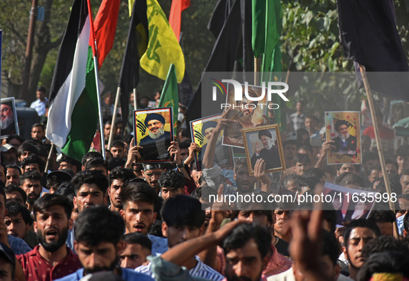 Shiite Muslims carry pictures of Hezbollah leader Hassan Nasrallah as they shout anti-Israel slogans during a demonstration to show their an...