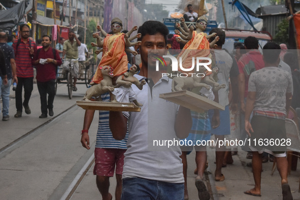 Laborers carry an idol of Goddess Durga to her pandal ahead of the Durga Puja festival in Kolkata, India, on October 2024. 