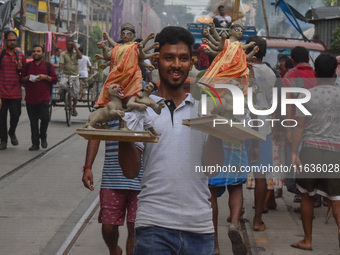 Laborers carry an idol of Goddess Durga to her pandal ahead of the Durga Puja festival in Kolkata, India, on October 2024. (