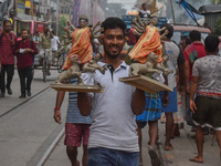 Laborers carry an idol of Goddess Durga to her pandal ahead of the Durga Puja festival in Kolkata, India, on October 2024. (