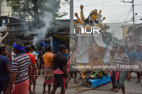 Laborers carry an idol of Goddess Durga to her pandal ahead of the Durga Puja festival in Kolkata, India, on October 2024. 