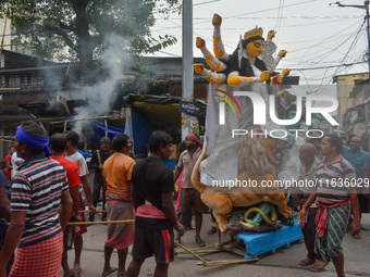 Laborers carry an idol of Goddess Durga to her pandal ahead of the Durga Puja festival in Kolkata, India, on October 2024. (