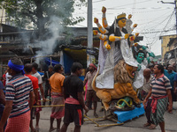 Laborers carry an idol of Goddess Durga to her pandal ahead of the Durga Puja festival in Kolkata, India, on October 2024. (