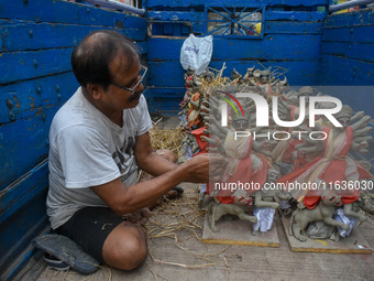 An artist packs small idols of Goddess Durga for transportation ahead of the Durga Puja festival in Kolkata, India, on October 4, 2024. (