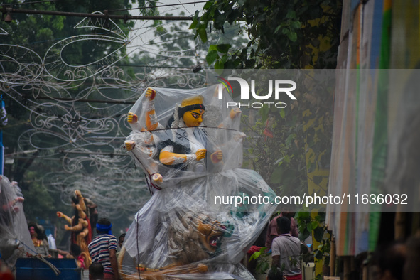 Laborers carry an idol of Goddess Durga to her pandal ahead of the Durga Puja festival in Kolkata, India, on October 2024. 