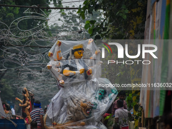 Laborers carry an idol of Goddess Durga to her pandal ahead of the Durga Puja festival in Kolkata, India, on October 2024. (