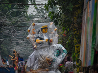 Laborers carry an idol of Goddess Durga to her pandal ahead of the Durga Puja festival in Kolkata, India, on October 2024. (