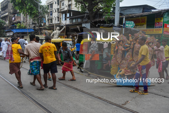 Laborers carry an idol of Goddess Durga to her pandal ahead of the Durga Puja festival in Kolkata, India, on October 2024. 